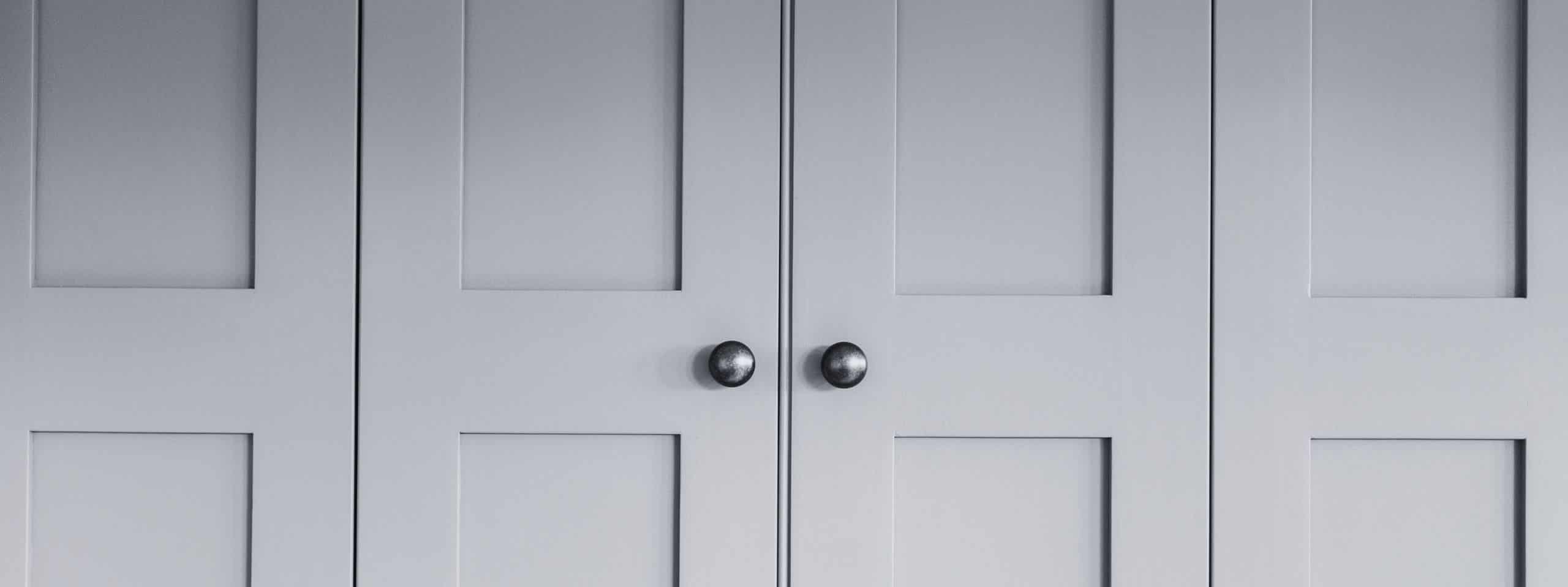 Gray cabinet doors with two round knobs.