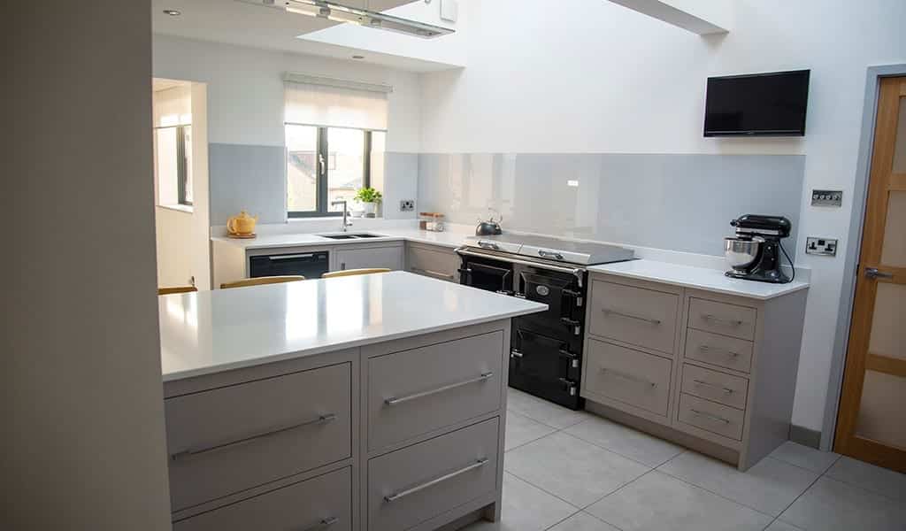 Modern kitchen with white countertops, appliances, and soft lighting.
